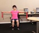 Stretching arms sideways; seated